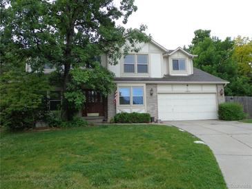 Charming two-story home with a well-manicured lawn, mature shade tree, and a two-car garage at 13651 Silverton Dr, Broomfield, CO 80020