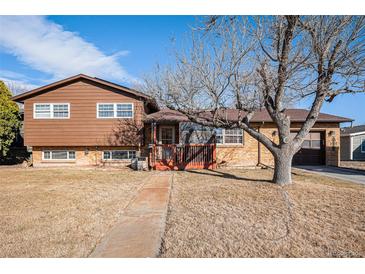 Charming split-level home with a wood and brick exterior and inviting front porch at 860 S 7Th Ave, Brighton, CO 80601