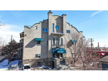Exterior building entrance with blue awnings and a vintage architectural style at 108 W Byers Pl # G4, Denver, CO 80223