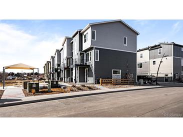 Modern townhome exterior with two-tone siding and a small front yard at 2676 W 68Th Ave, Denver, CO 80221