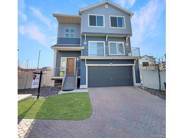 Modern two-story home with blue siding, a front-facing garage, and a small front lawn at 17908 E 54Th Ave, Denver, CO 80249