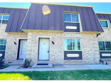 Inviting townhome exterior with brick facade, front door, windows, and well-maintained landscaping at 5677 S Lowell Blvd, Littleton, CO 80123