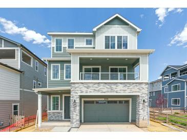 Inviting two-story home featuring stylish gray siding, brick accents, and a covered front porch at 8376 Cokedale Dr, Littleton, CO 80125
