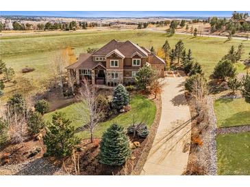 Gorgeous two-story home featuring a tile roof, well-manicured lawn, and a long driveway at 5582 Twilight Way, Parker, CO 80134