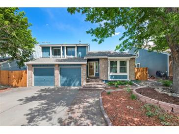 Charming two-story home with blue siding, brick accents, two-car garage, and well-maintained landscaping at 7226 S Eagles Nest Cir, Littleton, CO 80127