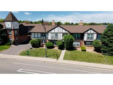 Charming townhome exterior with well-maintained landscaping and a distinctive clock tower feature at 3825 S Monaco Pkwy # 111, Denver, CO 80237