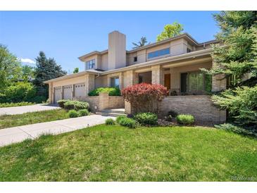 Stunning two-story home featuring a manicured lawn, a three-car garage, and a covered porch entrance at 4800 E Cedar Ave, Denver, CO 80246