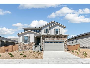 Charming two-story home featuring stone accents, gray siding and a two-car garage at 4451 Soapberry Pl, Castle Rock, CO 80108
