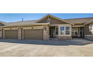 Inviting home exterior with brick accents, attached garages, and well-maintained landscaping at 15217 Xenia St, Thornton, CO 80602