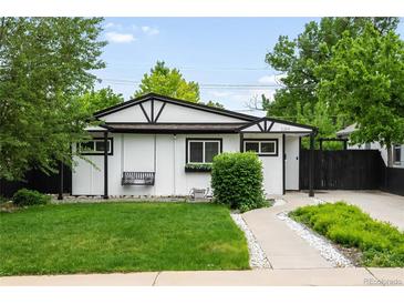 Charming white and black home featuring a swing, black framed windows, and a well-manicured lawn at 1264 Uinta St, Denver, CO 80220