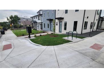 Modern townhome with fresh landscaping, bike rack, and light-colored exterior paint scheme at 1295 Utica St, Denver, CO 80204