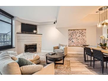 Bright living room with a fireplace, large windows, and comfortable seating at 1350 Lawrence St # 2F, Denver, CO 80204