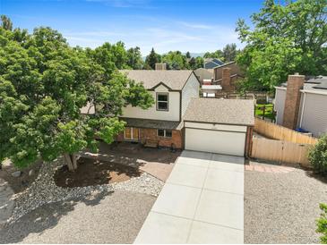 Charming two-story home with a large front yard, mature tree, and a two-car garage at 10378 W Weaver Ave, Littleton, CO 80127