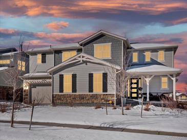 Two-story house with gray siding, stone accents, and a covered porch at 27750 E Lakeview Dr, Aurora, CO 80016