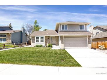 Charming two-story home with a well-manicured lawn and attached two-car garage at 12089 W Burgundy Ave, Littleton, CO 80127