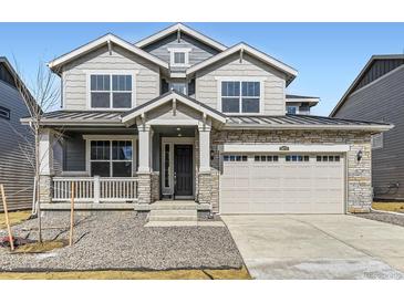 Charming two-story home featuring stone accents, gray siding, and a covered front porch at 24715 E Evans Dr, Aurora, CO 80018