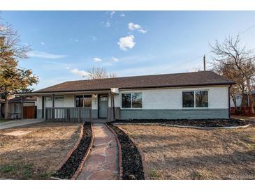 Charming single-story home with a landscaped front yard and welcoming stone pathway at 795 Troy Ct, Aurora, CO 80011