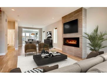 Bright living room featuring a modern fireplace, hardwood floors, and neutral decor at 3122 Perry St, Denver, CO 80212
