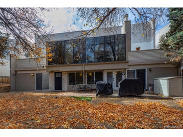 View of the house from backyard, with a patio, grill, and yard covered in fall leaves at 2362 S Troy St, Aurora, CO 80014