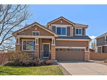 Inviting two-story home featuring a two-car garage, stone accents, and a well-manicured lawn at 6786 Halifax Ave, Castle Rock, CO 80104