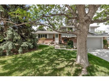 Charming two-story home with brick accents, lush lawn, mature trees and manicured landscaping at 6211 S Garfield Dr, Centennial, CO 80121