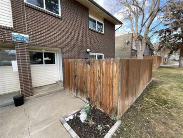 Brick townhouse exterior with fenced yard and walkway at 8019 Wolff St # H, Westminster, CO 80031