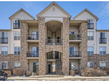 Multi-story condo building with stone accents and multiple balconies on a sunny day at 7292 S Blackhawk St # 2-306, Englewood, CO 80112