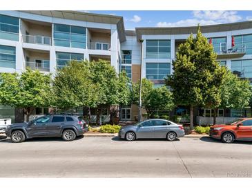 Modern condo building with covered entry, large windows and mature trees at 2958 Syracuse St # 214, Denver, CO 80238