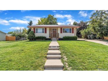 Charming single-story home featuring well-maintained lawn, inviting walkway, and colorful landscaping at 1308 W 102Nd Ave, Northglenn, CO 80260