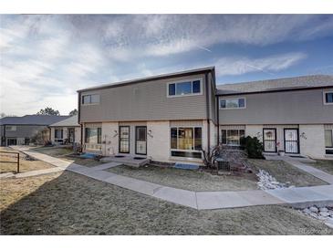 Tan siding townhouse exterior with a well-maintained lawn and walkway at 4266 W Pondview Dr, Littleton, CO 80123