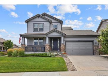 Charming gray two-story home featuring a covered front porch, stone accents, and a well-manicured lawn at 8182 Grady Cir, Castle Rock, CO 80108