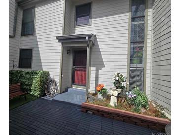 Inviting front entrance with decorative planters and a cozy bench, creating a warm welcome to the home at 7925 W Layton Ave # 322, Littleton, CO 80123