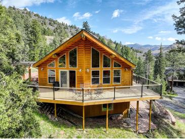 Charming cabin with large windows and a spacious deck, perfect for enjoying the mountain views at 1353 Elk Valley Dr, Evergreen, CO 80439