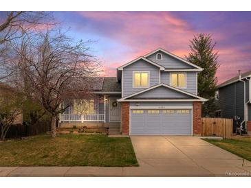 Charming two-story home with a blue exterior, front porch, well-manicured lawn, and an attached two-car garage at 11402 Benton Ct, Westminster, CO 80020