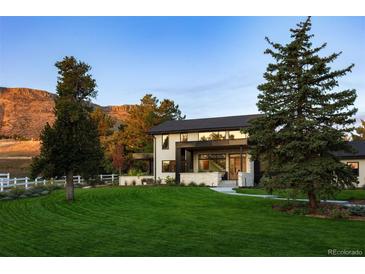 Stunning modern home boasting lush lawn, mature trees, and mountain views at 17326 W 57Th Ave, Golden, CO 80403