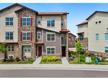 Beautiful townhome featuring a combination of stone and siding, and a well-maintained lawn at 2140 Santini Trl # F, Littleton, CO 80129