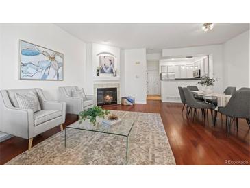 Bright living room featuring a fireplace, two chairs, hardwood floors, and glass coffee table at 2855 Rock Creek Cir # 191, Superior, CO 80027