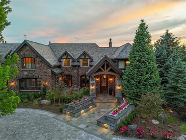 A beautiful brick home featuring professional landscaping, a slate roof, and a stone walkway at 4030 E Forbes Ct, Greenwood Village, CO 80121