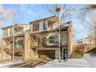 Modern two-story townhome with attached garage and snow-covered front yard at 680 Crescent Ln, Lakewood, CO 80214