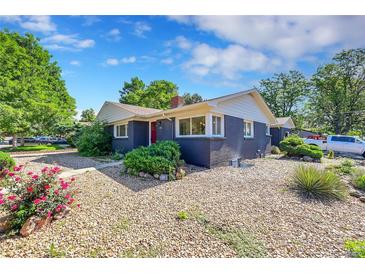 Charming home with a well-maintained rock yard and a vibrant red front door, complemented by lush greenery and blue skies at 1596 S Stuart St, Denver, CO 80219