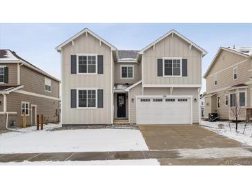 Two-story house with beige siding, white trim, and a two-car garage at 1391 Zenith Heights Ct, Erie, CO 80516