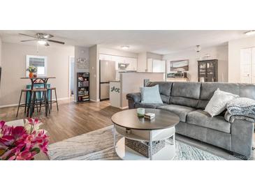 Open-concept living room with hardwood floors, modern furniture, and natural light at 4569 S Lowell Blvd # C, Denver, CO 80236