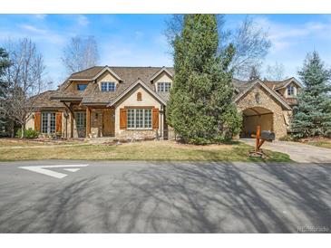 Charming home featuring stone accents, wood shutters, a porte-cochère and professionally landscaped yard at 1 Gooseberry Ln, Cherry Hills Village, CO 80113