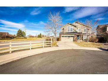 Charming two-story home with an attached garage and a well-maintained yard on a sunny day at 23201 E Orchard Pl, Aurora, CO 80015