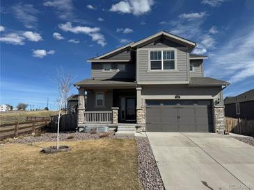 Charming two-story home featuring a covered porch, two-car garage, and meticulous landscaping at 914 Peach Leaf Ln, Elizabeth, CO 80107