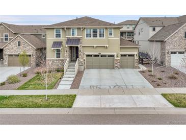 Two-story home with a three-car garage, stone accents, and concrete driveway in a residential neighborhood at 22472 E Narrowleaf Cir, Aurora, CO 80016
