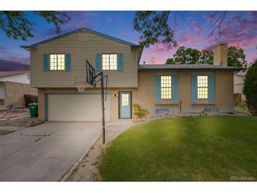 Charming home with a two-car garage, a basketball hoop, and blue shutters under a sky filled with sunset colors at 1549 S Evanston St, Aurora, CO 80012