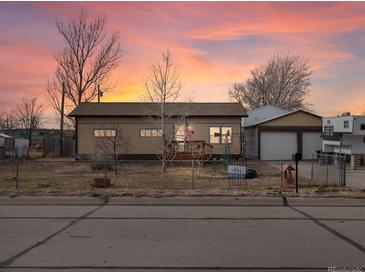 Ranch style home with attached garage and mature trees at 635 2Nd St, Bennett, CO 80102