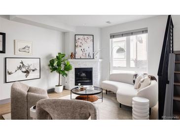 Bright living room features a modern fireplace, neutral decor, and large windows for ample natural light at 2820 W 26Th Ave # 101, Denver, CO 80211
