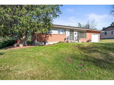 Charming single-story home with a well-manicured lawn, mature trees, and beautiful landscaping at 3061 S Mabry Ct, Denver, CO 80236